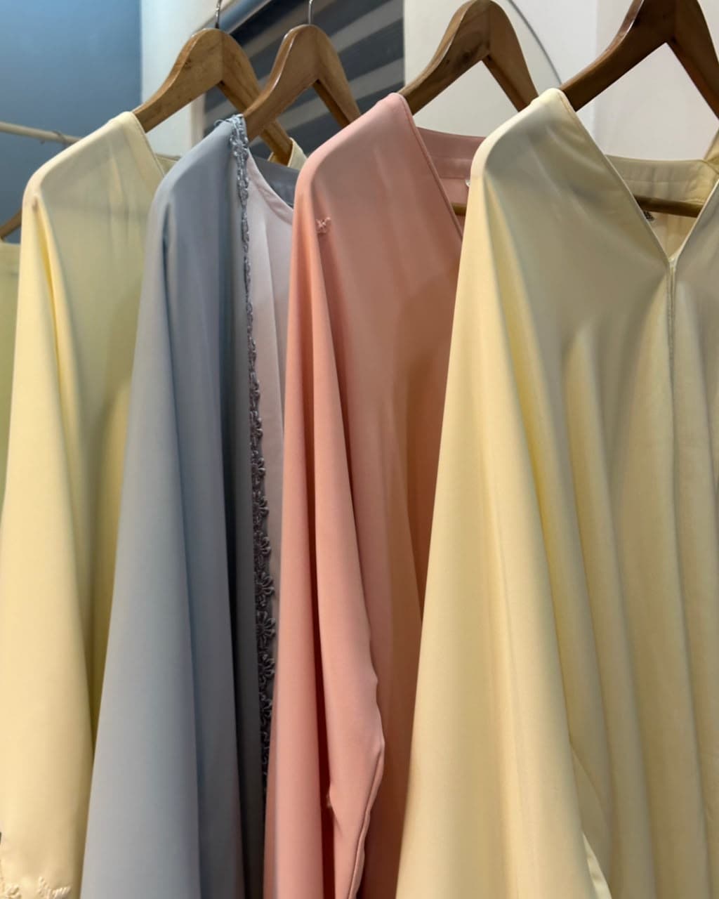 HOOR abayas hanging on rack — pastel collection
